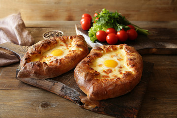 Couple Khachapuri Adjara traditional Georgian dishes. Baked bread stuffed with cheese and eggs.