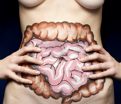 Intestine painted on woman's stomach against black background
