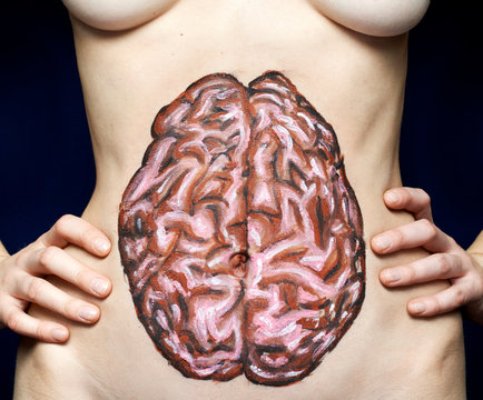 Brain painted on woman's stomach against black background