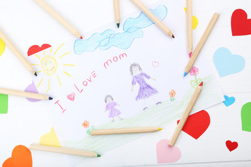 Greeting card for Mothers Day with colorful paper hearts and pencils on wooden table
