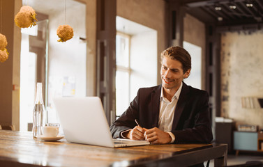 Young handsome businessman conducting negotiations with investors. Electronic business. Alternative...