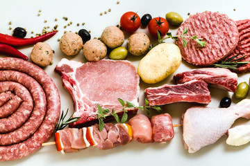 different types of raw meat: chicken thighs, pork and beef burgers, ribs and kebabs, turkey...
