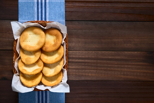 Traditional Chilean Sopaipilla Fried Pastries Made Of A Bread-like Leavened Dough Served In A Basket, Photographed Overhead On Dark Wood With Natural Light