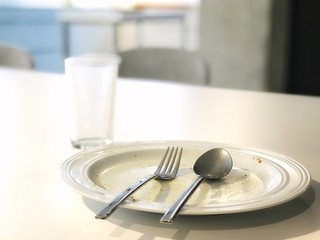 Selected focus, Empty and clear white dish with stainless spoon and fork, and vacant glass on white...