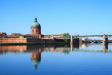 Fototapeta premium The Saint Pierre bridge passes over the Garonne river and Hospital de La Grave in Toulouse, the French pink city and city of Art and History with an important architectural and artistic heritage Haute