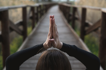 Fototapeta premium Girl meditating and practicing yoga in nature. Concept of wellness and relaxation