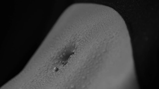 Beautiful female body with water drops on a black background