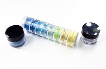 Make-up eye shadows in plastic case.and stacks  Cosmetic bottle containers isolated on white background, copy space