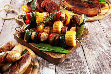 Assorted delicious grilled meat and skewer with vegetable on rustic table