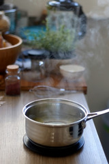 Pan with boiling water and olive oil, for cooking polenta. Selective focus.