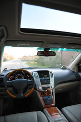 Fototapeta premium Modern luxury prestige car interior, dashboard, steering wheel. Perforated leather, wooden interior.