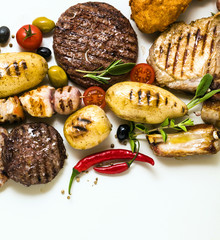 BBQ meat party with different types of meat: beef burgers, pork ribs, turkey meatballs, chicken thighs breaded with potatoes and tomatoes, spices and aromatic herbs. Summer menu for gourmets, rest