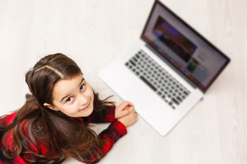 Top view of cute young girl using laptop