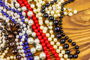 Different beads necklaces on wooden background