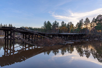 Old wooden bridge over the river in the forest