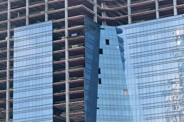 Fototapeta premium wall with window openings in a multi-storey high-rise residential building under construction from concrete and brick