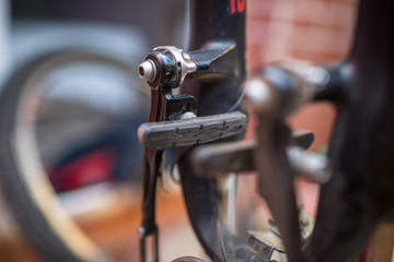 worn brake pads. male mechanic making service in bicycle repair shop, repairman fixinig bike brakes using special tool