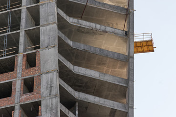 wall with window openings in a multi-storey high-rise residential building under construction from concrete and brick