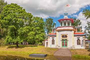 Fototapeta na wymiar Pavilion in style of Chinese pagoda on bank of pond in Alexander Park in Tsarskoye Selo