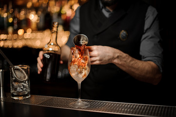 Bartender prepares cocktail on a bar counter