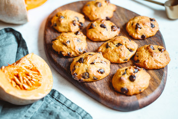 Pumpkin cookies with chocolate chips made from cake mix on a wooden tray.
