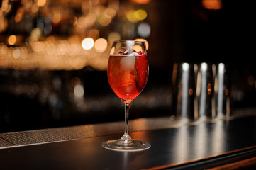 Red cocktail in glass on a bar counter