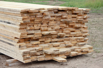 Tracked storage wooden planks. Materials for wooden housing. - obrazy, fototapety, plakaty