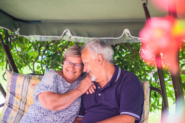 nice couple of beautiful caucasian senior 70 years old sit outdoor at home having fun with smiles...