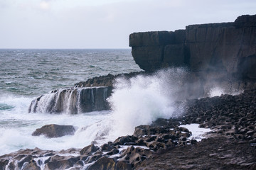 Waves crash on rocks off the coast of County Clare Ireland.