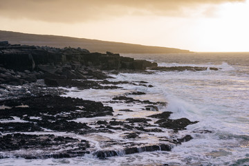 Fototapeta premium Sunset glows over hill and beach off the coast of County Clare Ireland.