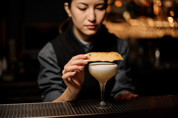 Bartender pours an alcohol cocktail in glass