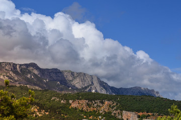Beautiful nature phenomenon. Thick descent clouds descend from the mountains directly into the...