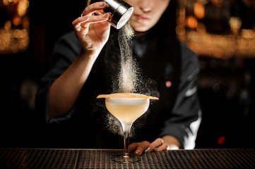 Bartender pours an alcohol cocktail in glass