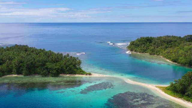 An island is surrounded by coral reefs off the coast of New Britain, Papua New Guinea.