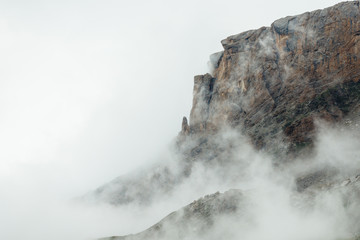 Edge of steep rocks in the mist. Copy space for text