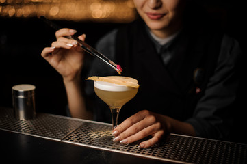Bartender pours an alcohol cocktail in glass