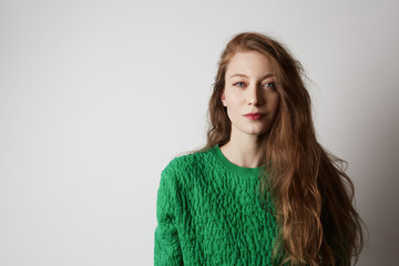 Fototapeta premium Youth and happiness female.Beautiful Caucasian teenage woman with long ginger hair and freckles, dressed casually, standing against blank white wall.Copy paste space, studio shot, model.