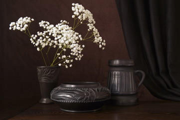 Background with black ceramics and white flowers - gypsophila
