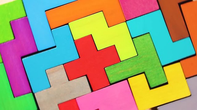 Top view on colorful wooden blocks folding on the wooden background. The concept of logical thinking.