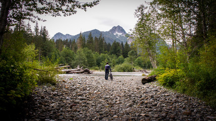 Fototapeta premium Man walking his bike toward a mountain