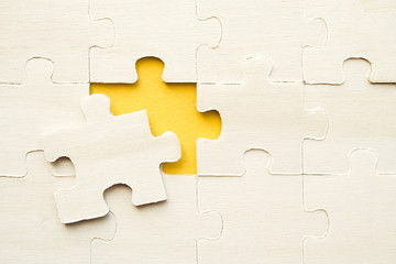Wooden puzzles on a yellow background, closeup, top view