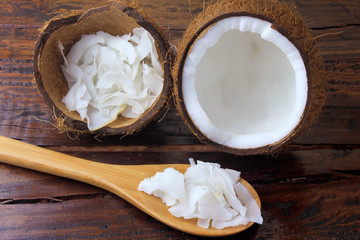 fresh coconut flakes and chips placed in bark isolated on rustic wooden background