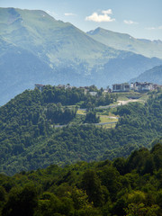 Fototapeta premium Hotel in the mountains among the green forest. Krasnaya Polyana, Sochi, Russia