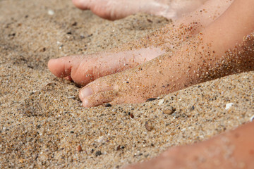 Woman tanned legs on sand beach. Travel concept.