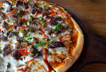 Beef pizza on a wooden table 