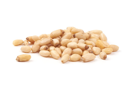 Cleaned dry pine nuts, close-up, isolated on white background