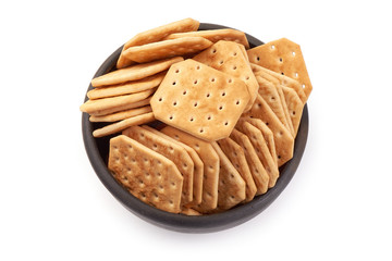 Bowl of salted cracker biscuits, top view, isolated on white background