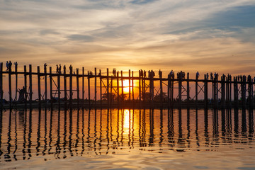 Fototapeta na wymiar Sunset over U Bein Wooden bridge with locals' and tourists' silhouettes, Mandalay, Myanmar