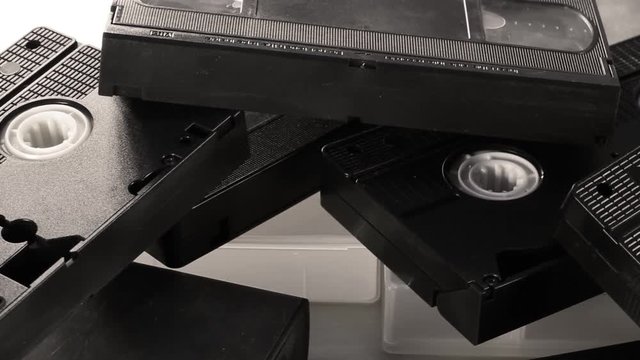 Slow camera rotation across retro VHS video tapes