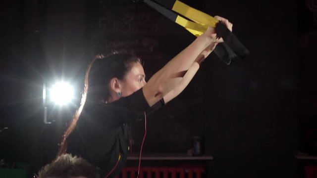 EMS electro stimulation sports equipment in gym. Woman doing exercises